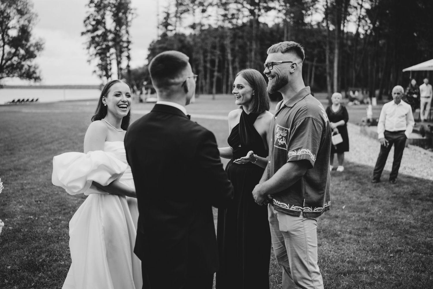 Small group of wedding guests chatting during an outdoor reception.