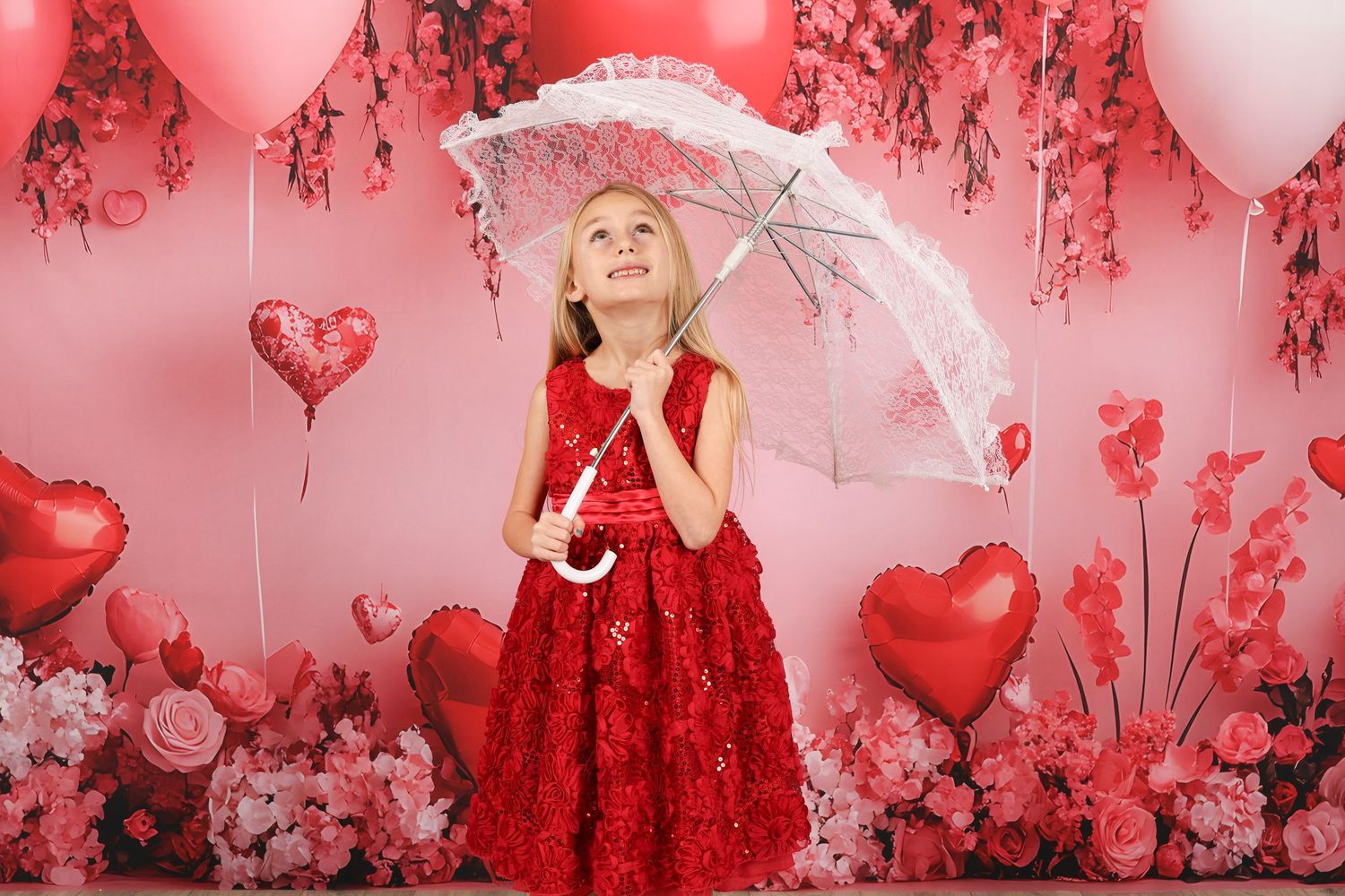 Playful Valentine's scene with white parasol and red heart decorations on pink background.