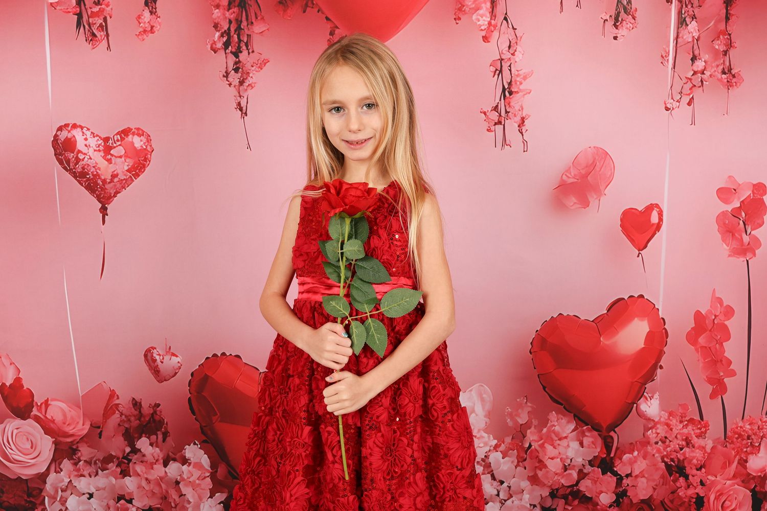Romantic Valentine's Day photo backdrop with heart balloons and pink roses.