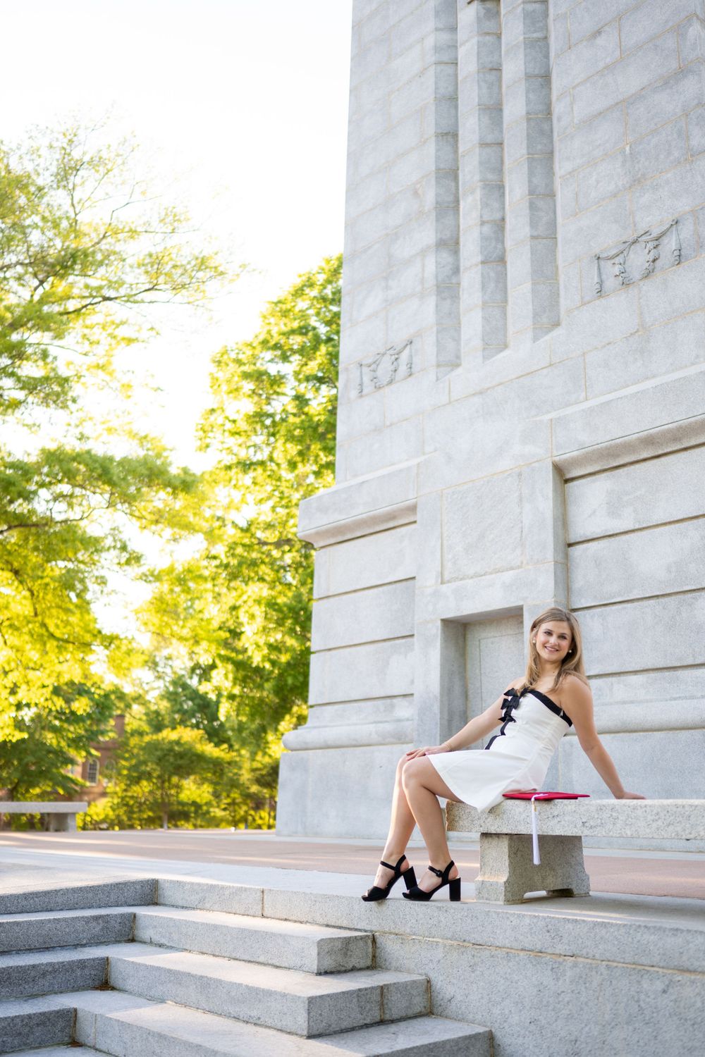A series of photos showing someone in formal attire posing gracefully on white marble steps at sunset.