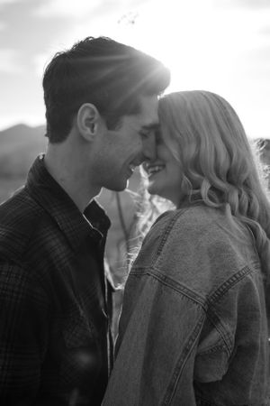 Intimate black and white portrait of a couple sharing a romantic moment at sunset.