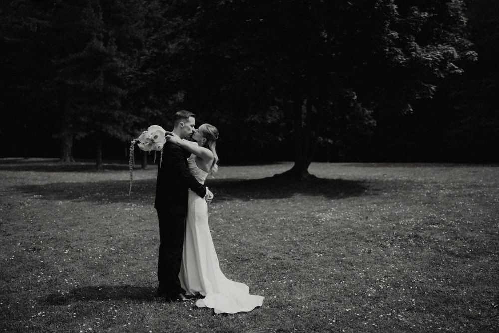A romantic black and white wedding photo captured in an outdoor garden setting.