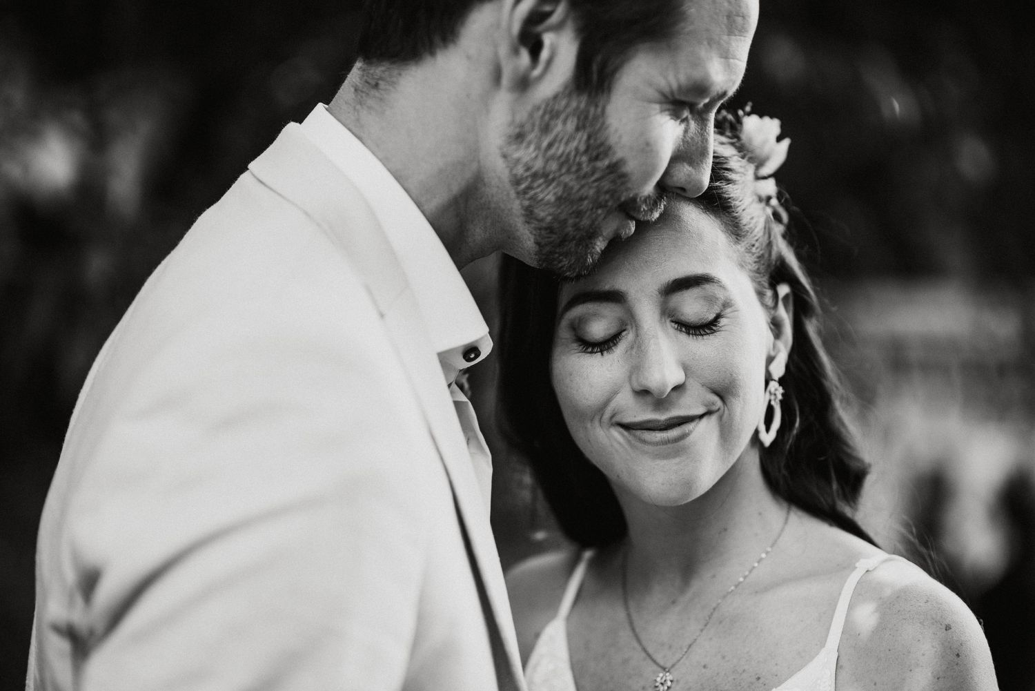 Intimate black and white moment between newlyweds during outdoor portraits.