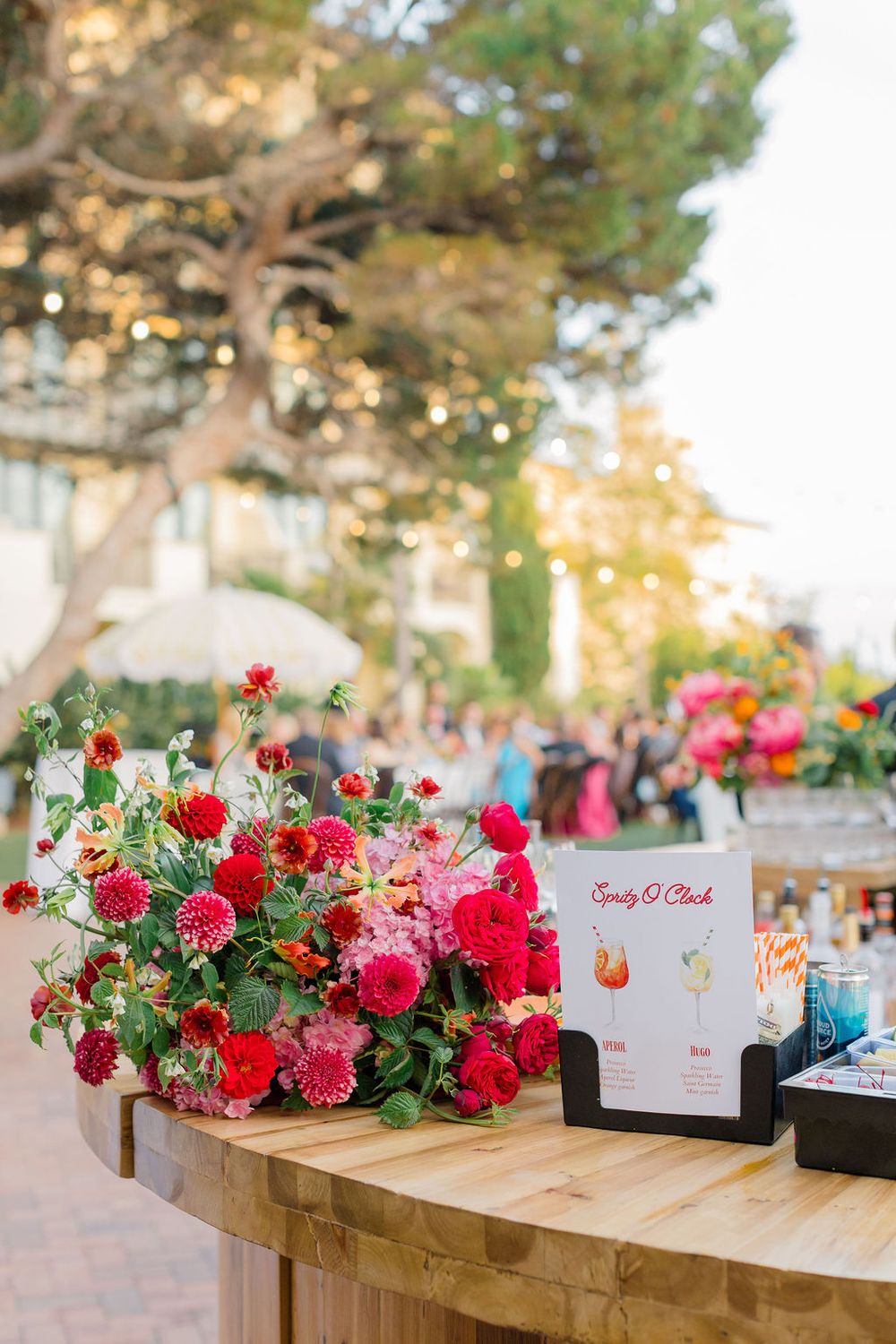 Wooden boxes filled with pink and red flowers sit alongside menu cards on a display table.