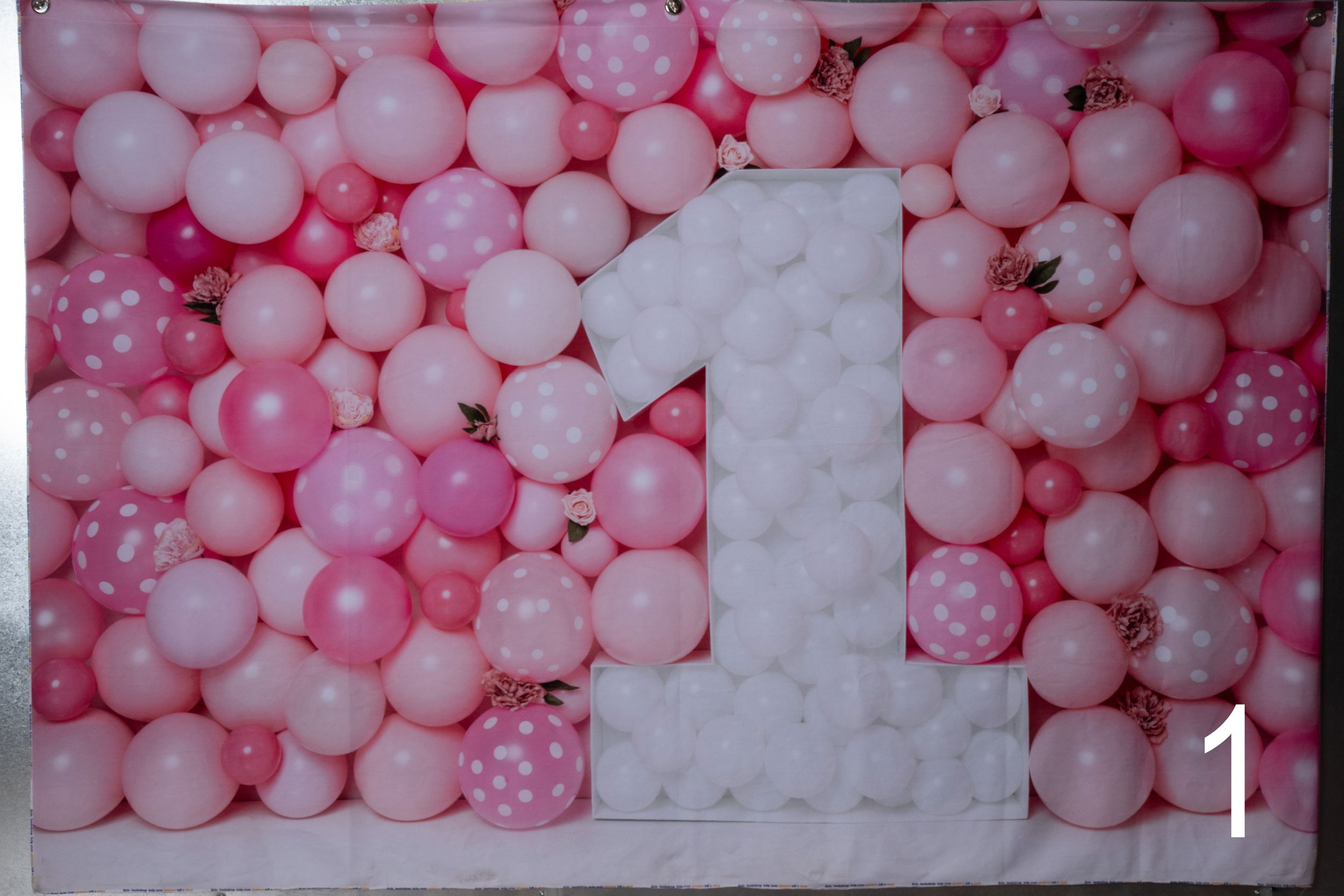 Pink and white balloon arch installation with polka dot accents creates a festive party backdrop.