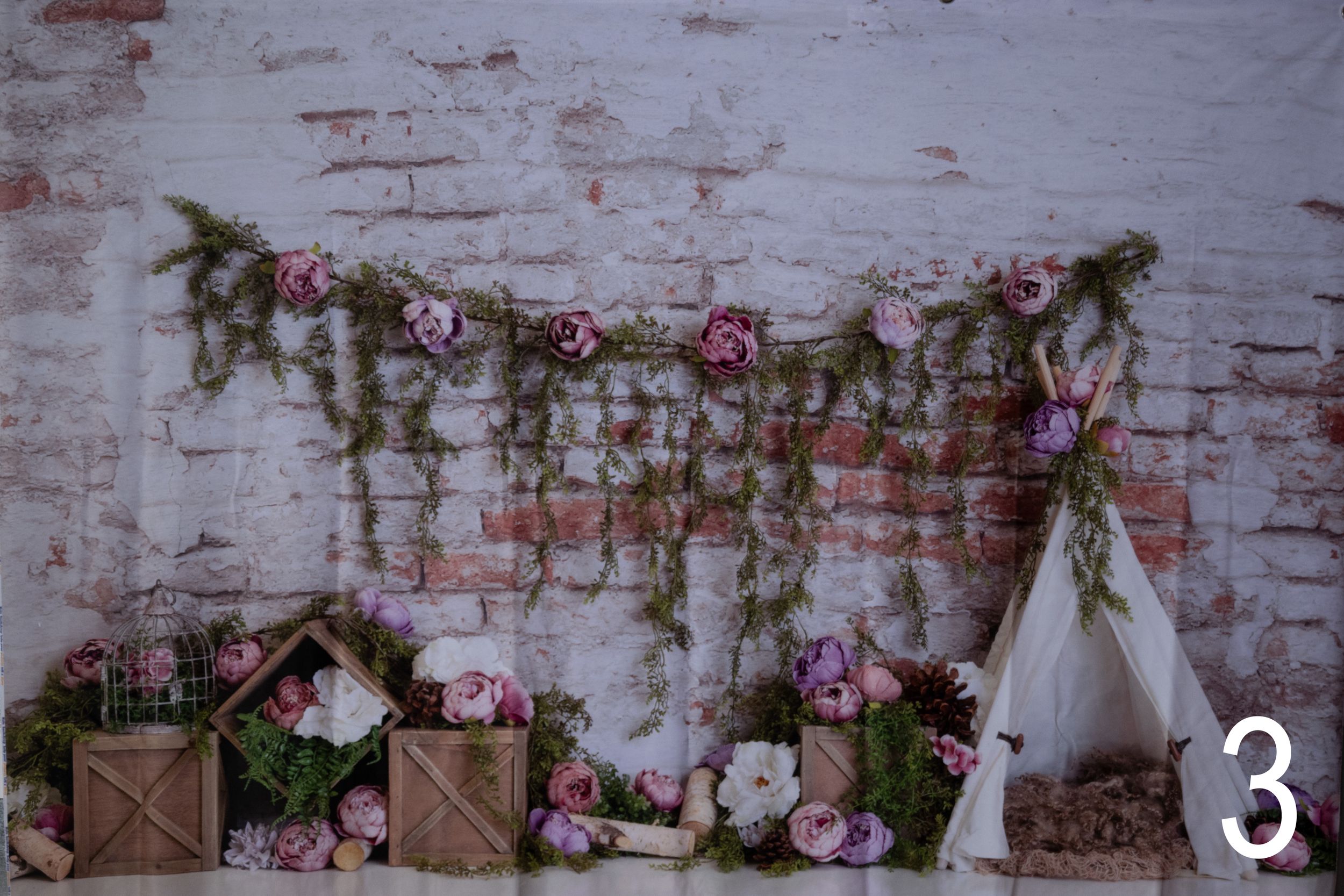 Rustic brick wall backdrop decorated with pink roses and white lanterns for an elegant wedding ceremony setting.