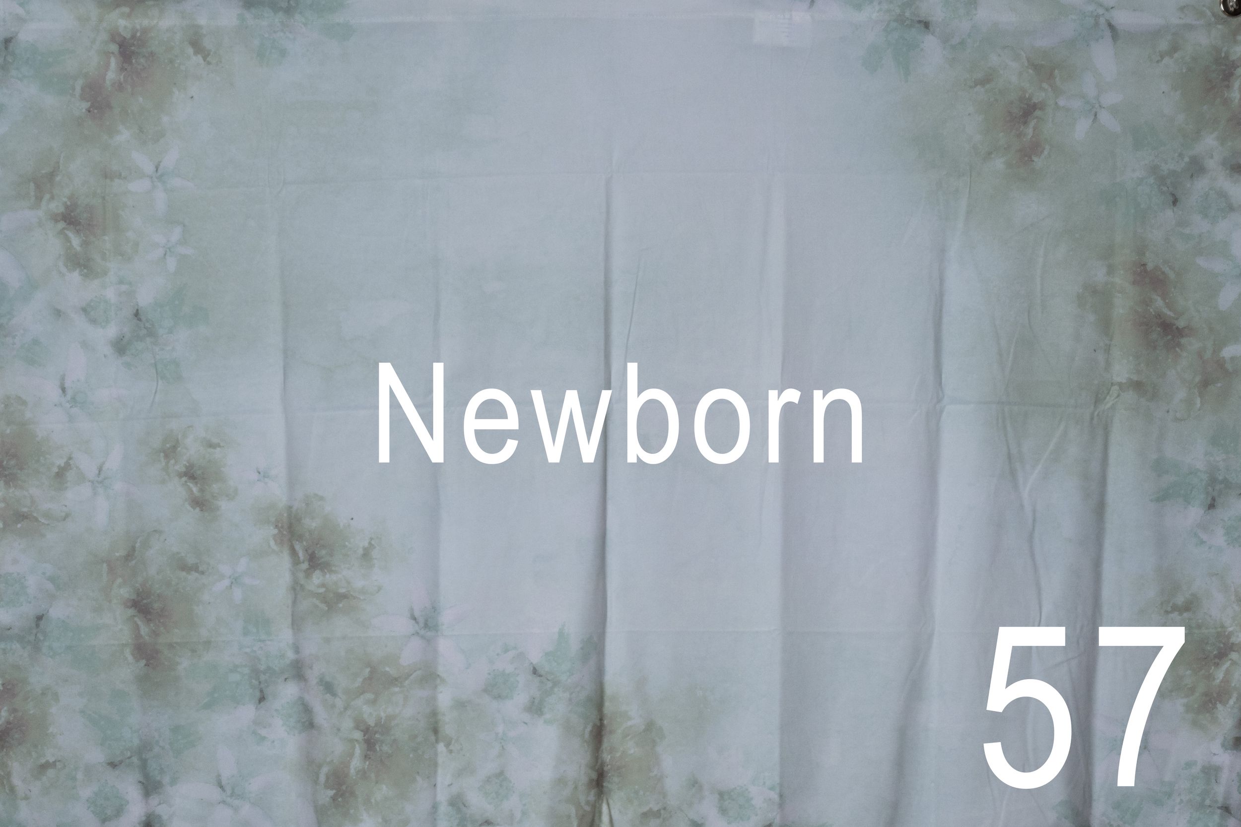 A newborn baby wrapped in a blanket lies sleeping while the number 57 appears in white text overlay.