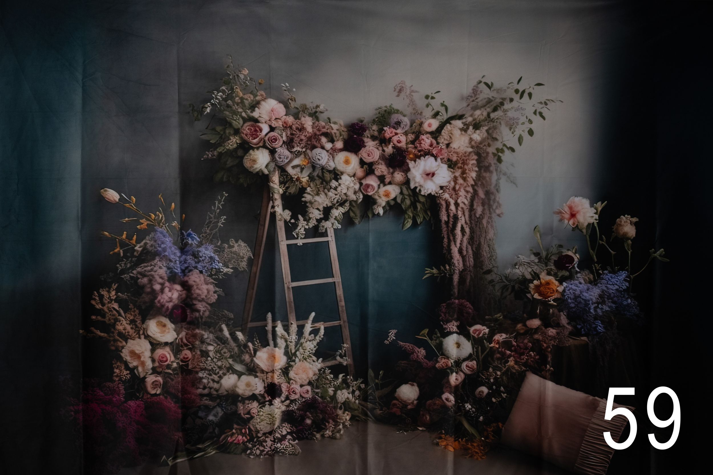 Moody floral arrangement with dark background featuring pink and purple blooms in dramatic lighting.