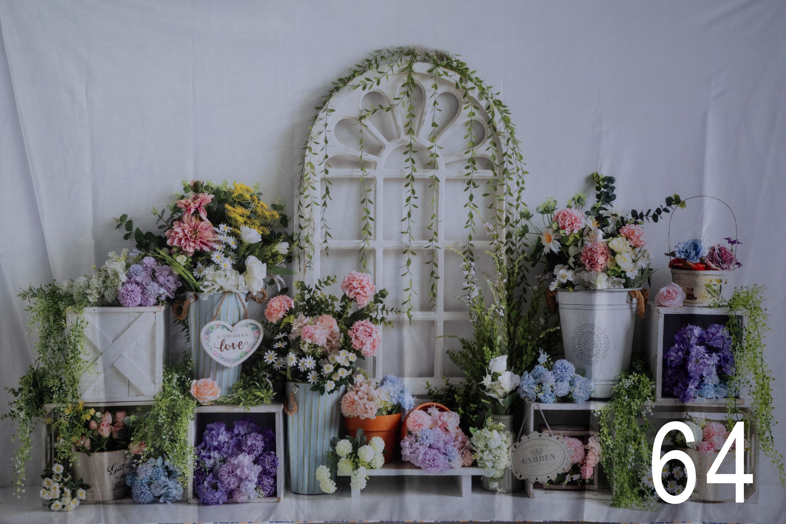 Elegant wedding decor setup with white trellis archway, floral arrangements, and pastel decorations in a romantic indoor setting.