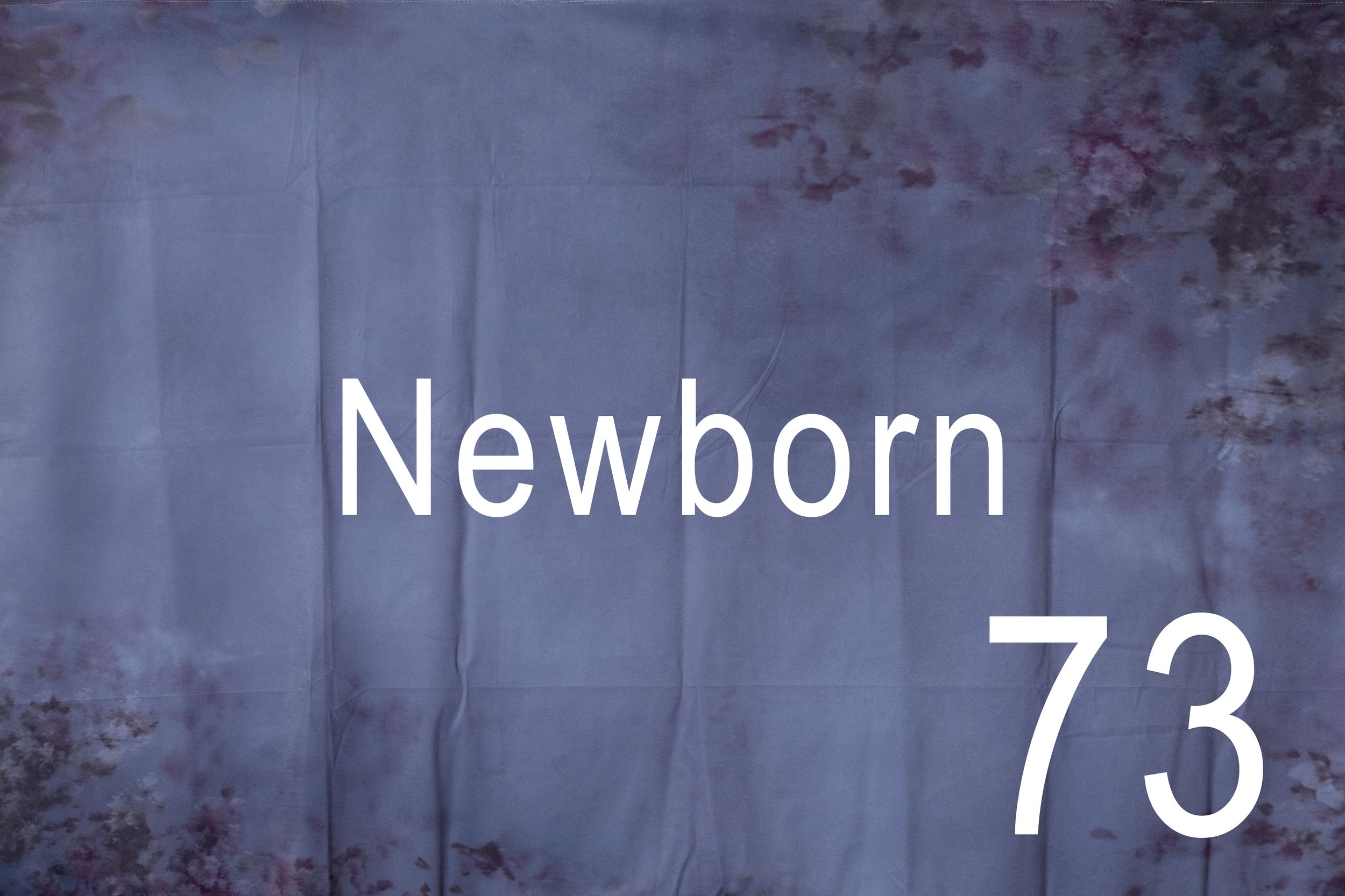 A newborn baby's tiny feet with the number 73 displayed in white text against a dark background.