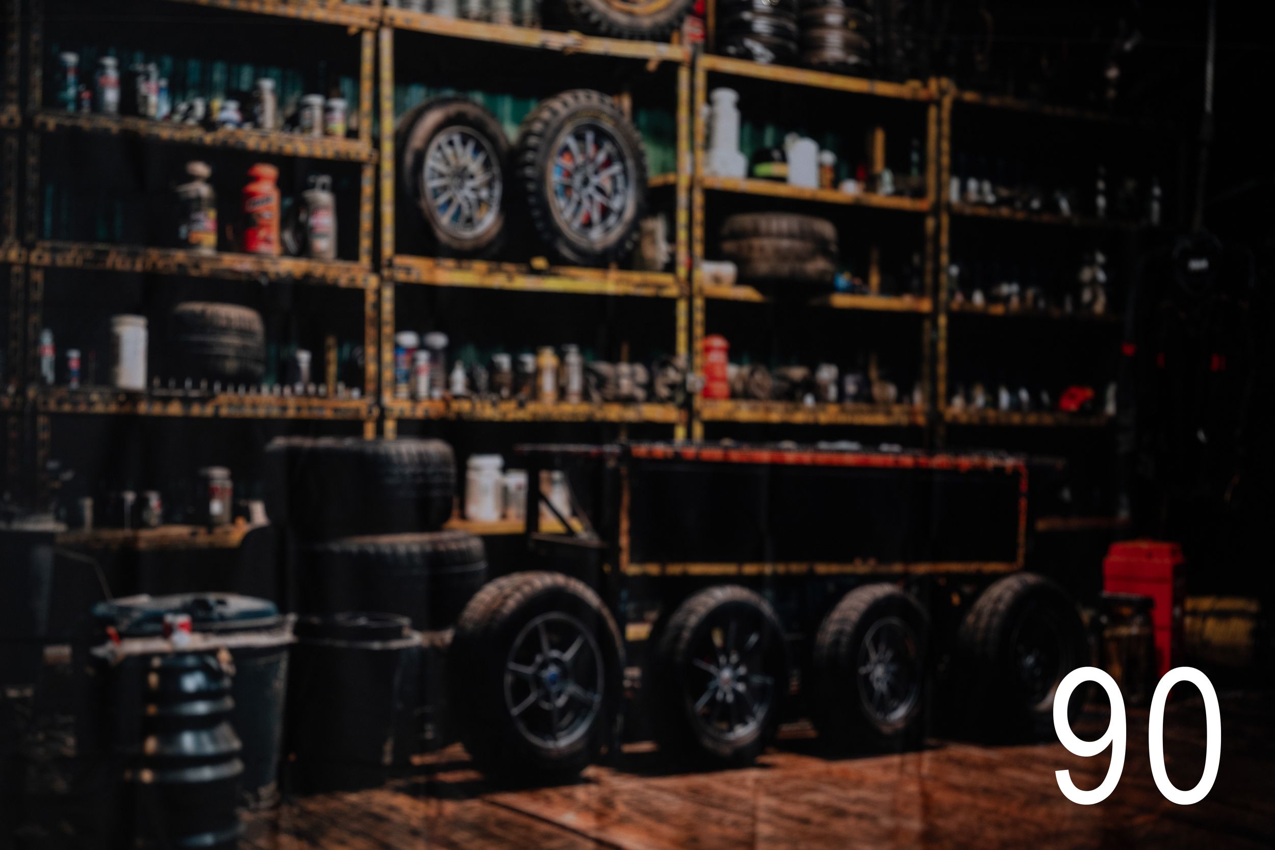 A dark, moody bar interior with vintage clocks on the wall and bottles lined up on wooden shelves.