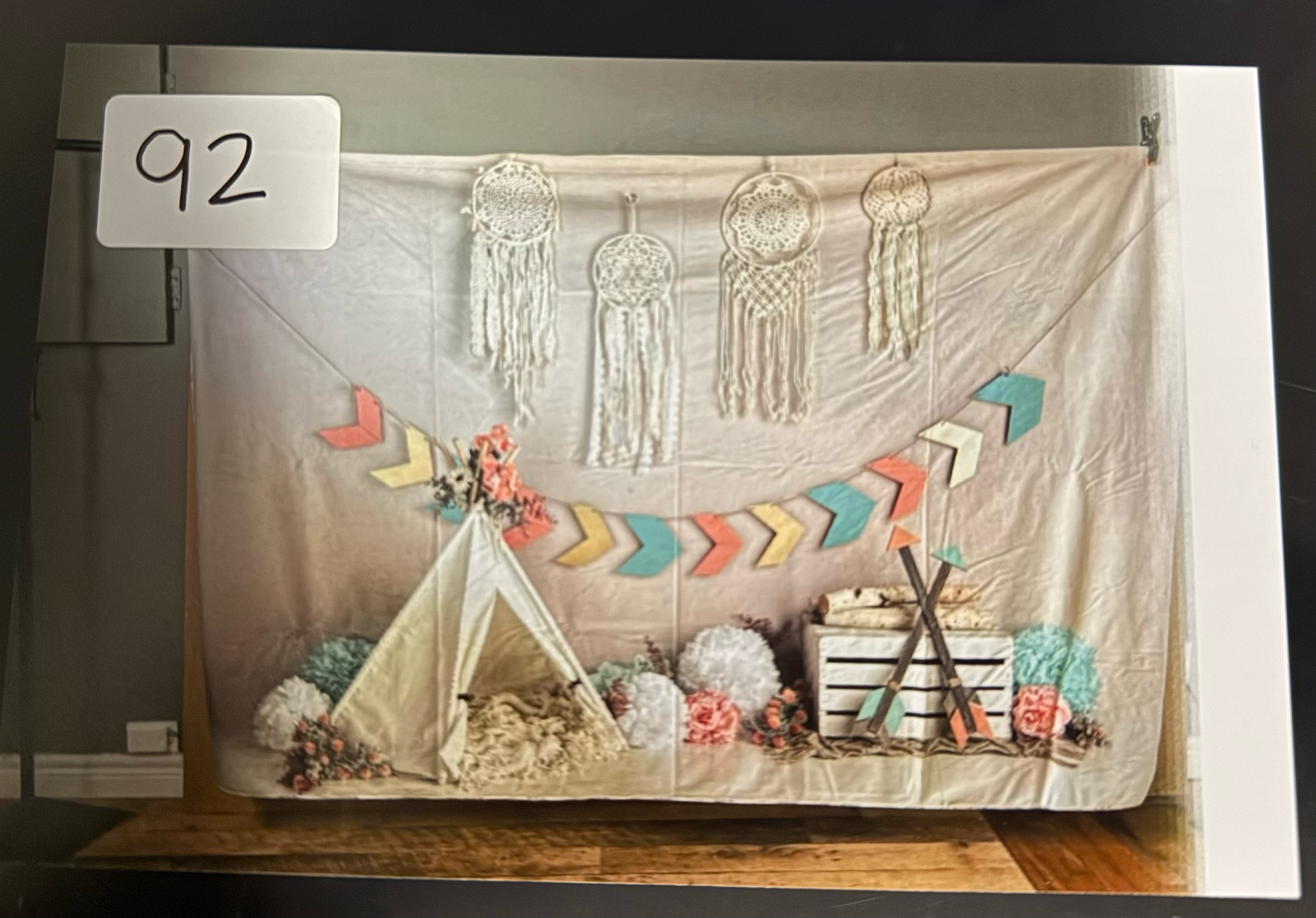 A decorative banner with colorful chevron patterns hangs against a light-colored fabric backdrop.