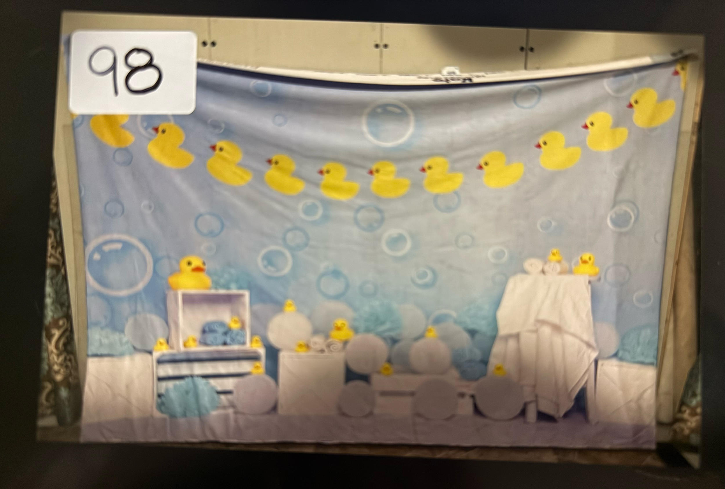 A series of five connected photos showing a stage backdrop with blue bubble patterns and yellow star decorations.