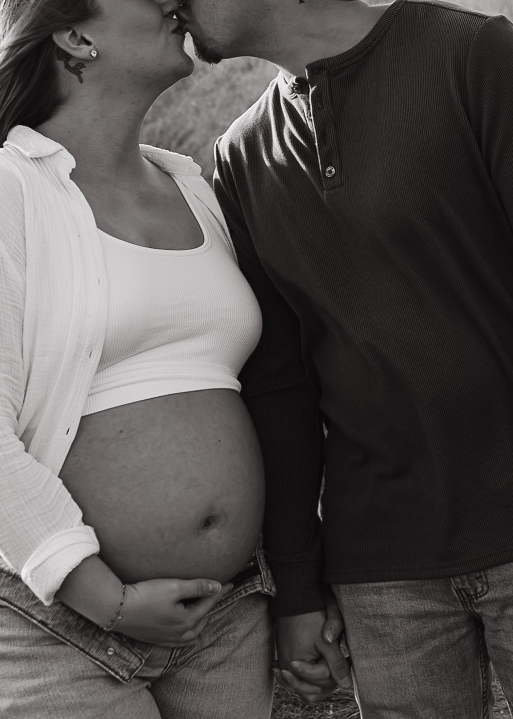 Black and white intimate maternity photo showing tender moment between couple.