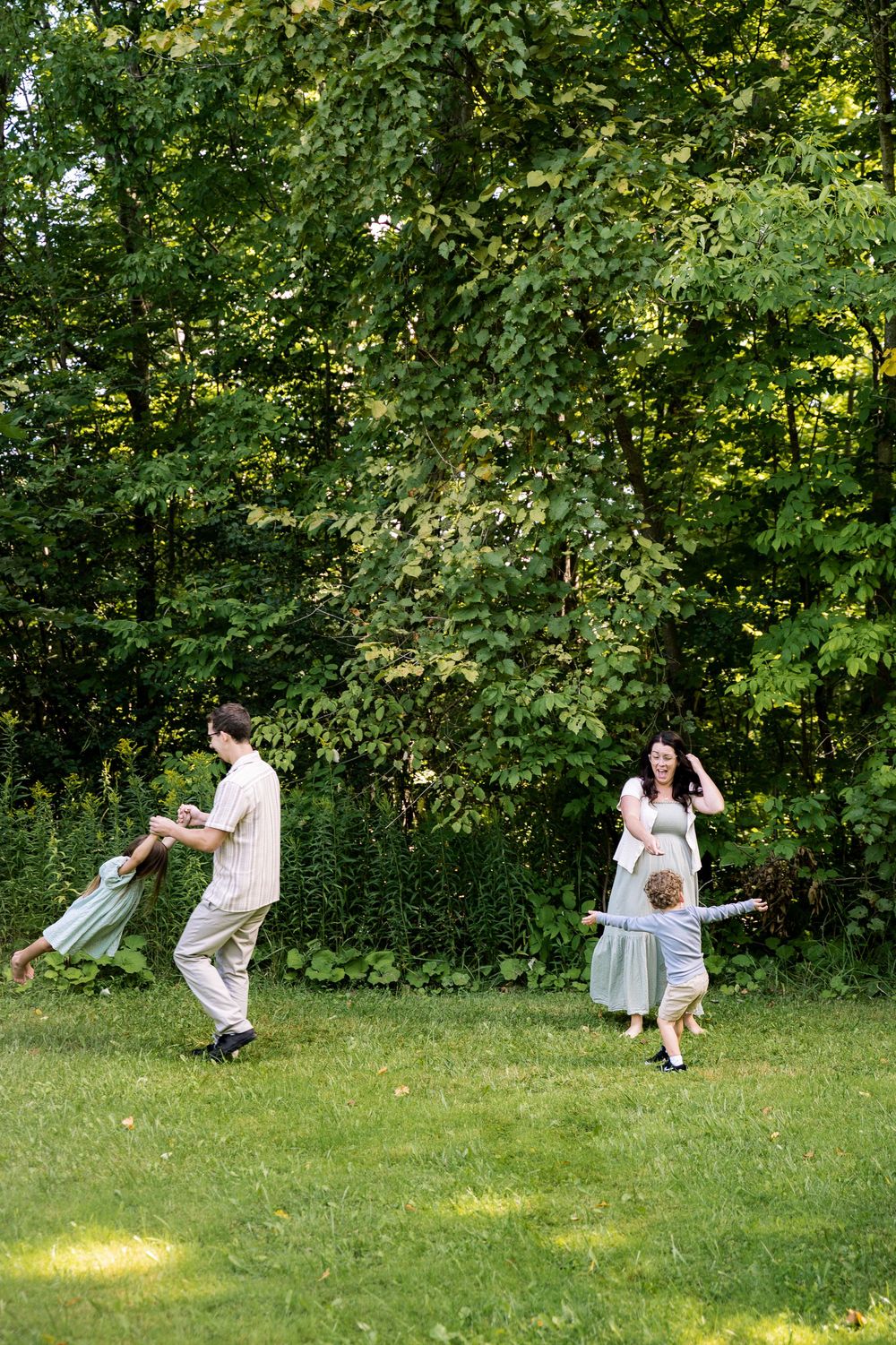 A playful sequence of people dancing and twirling in a lush green garden setting.