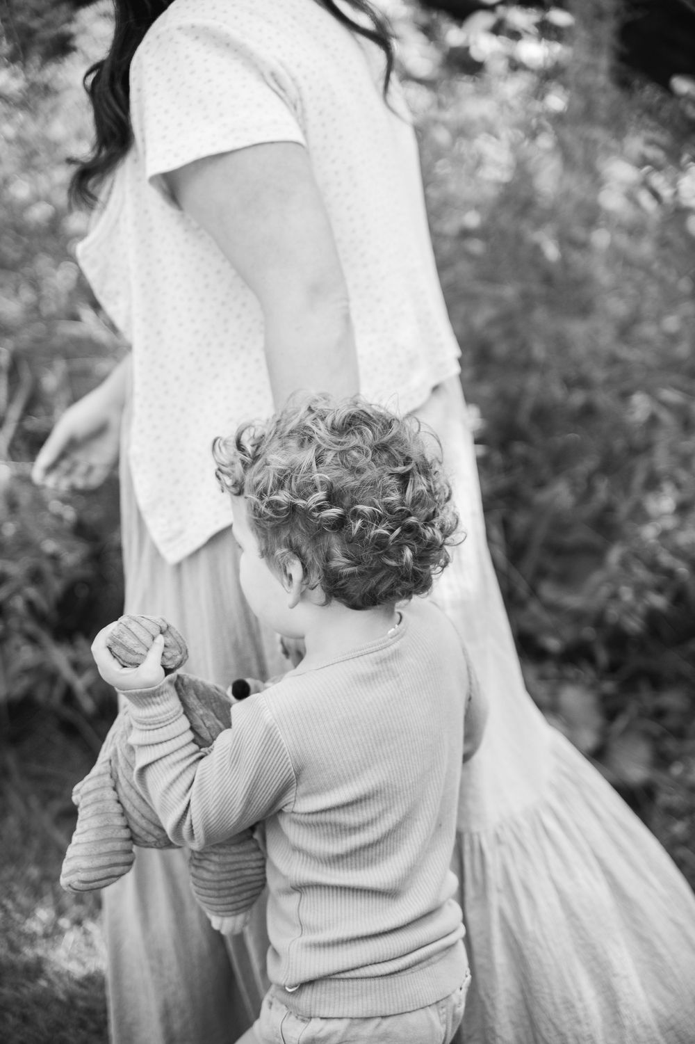 Black and white candid series showing tender parent-child interaction and embrace outdoors.
