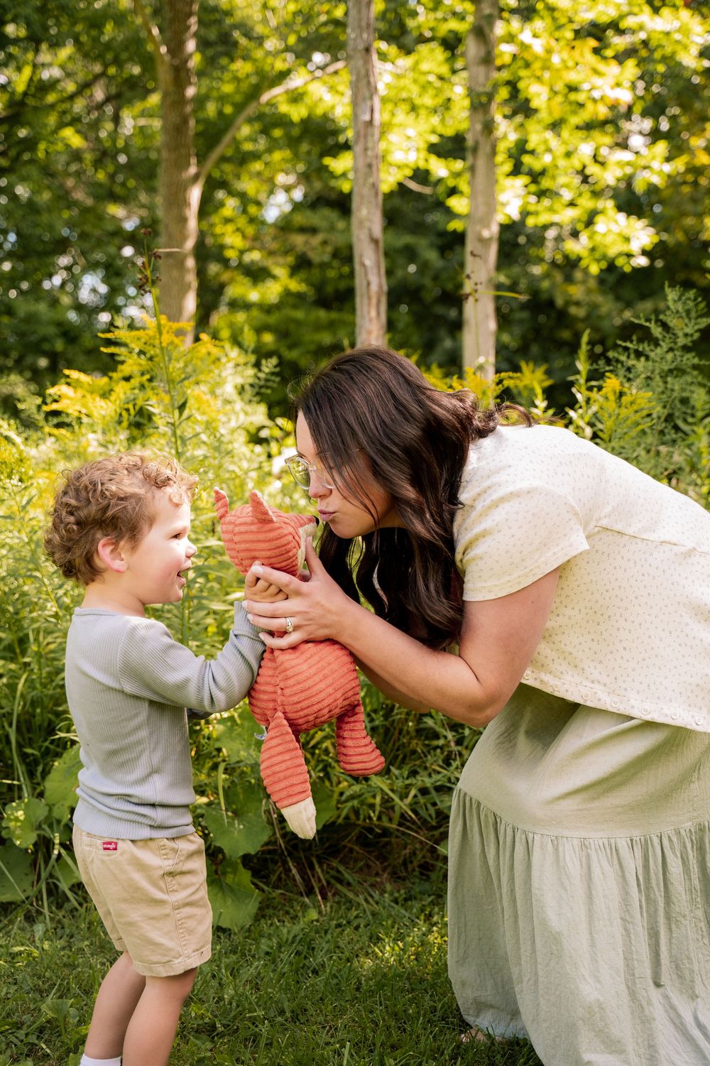 A heartwarming sequence showing a stuffed animal being shared in a sunny outdoor setting.