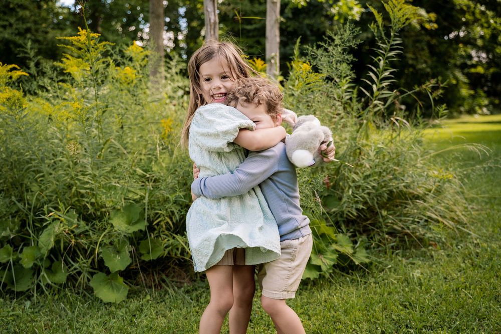 A series of candid outdoor family photos showing hugs and embraces in a lush green garden setting.