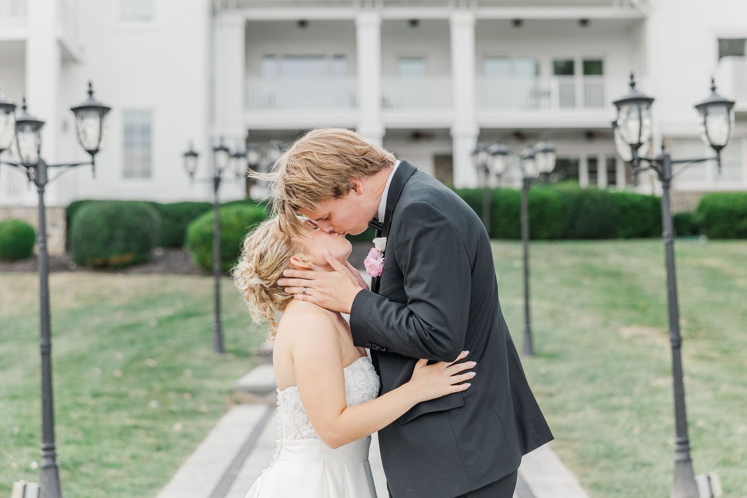 A romantic moment captured on a scenic walkway with decorative lamp posts.