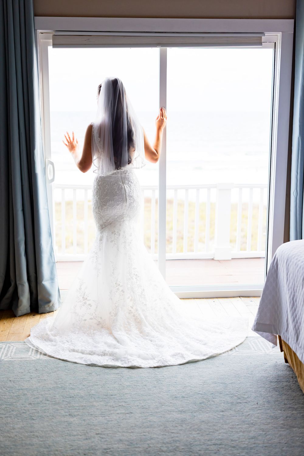 Three wedding dresses displayed in a row next to a window with natural light streaming in.