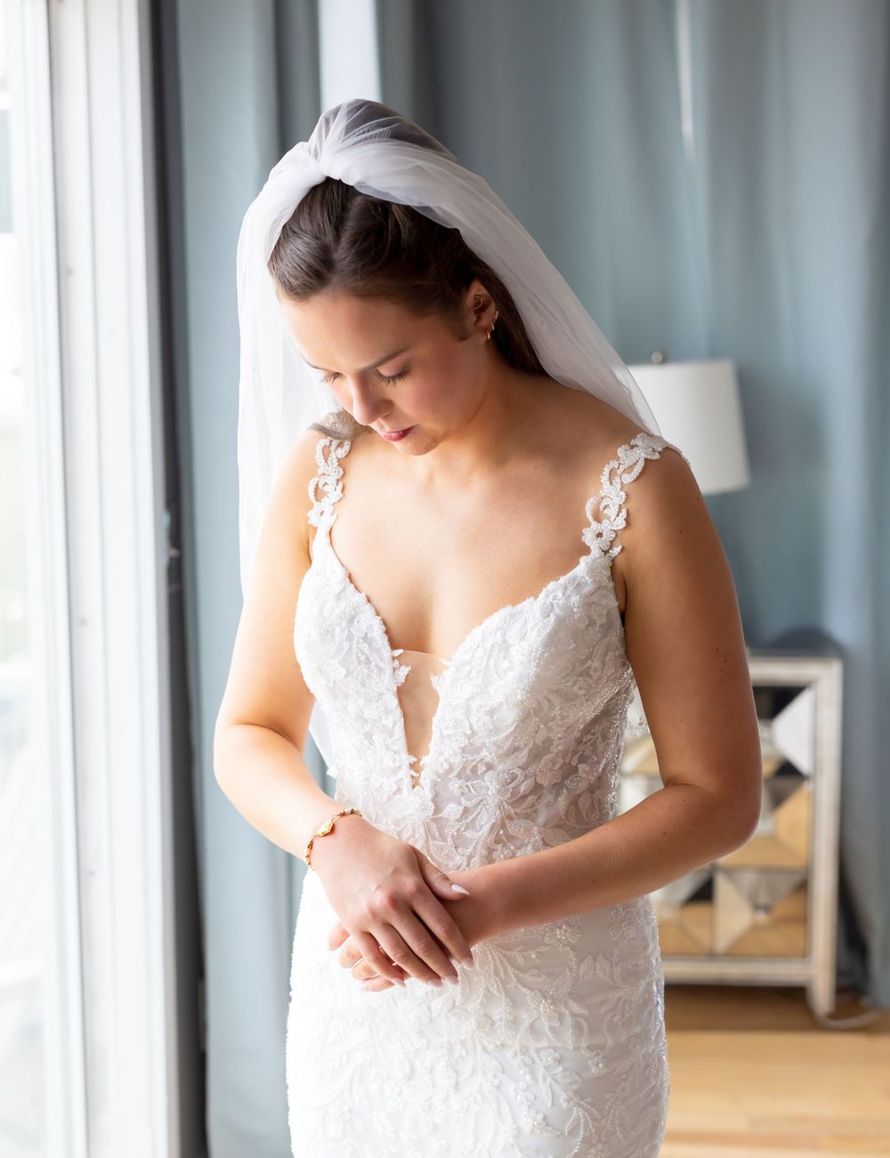 Close-up details of an elegant white lace wedding dress with delicate embroidery patterns.