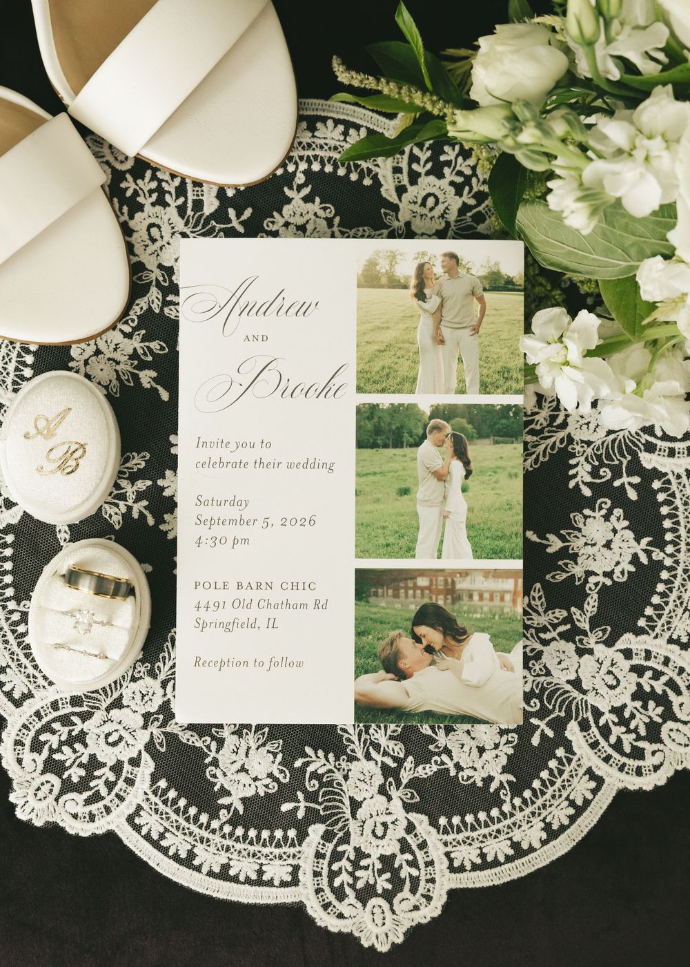 Elegant wedding invitation for Andrew and Sirocha displayed with bridal shoes, lace, and florals on a styled flat lay.