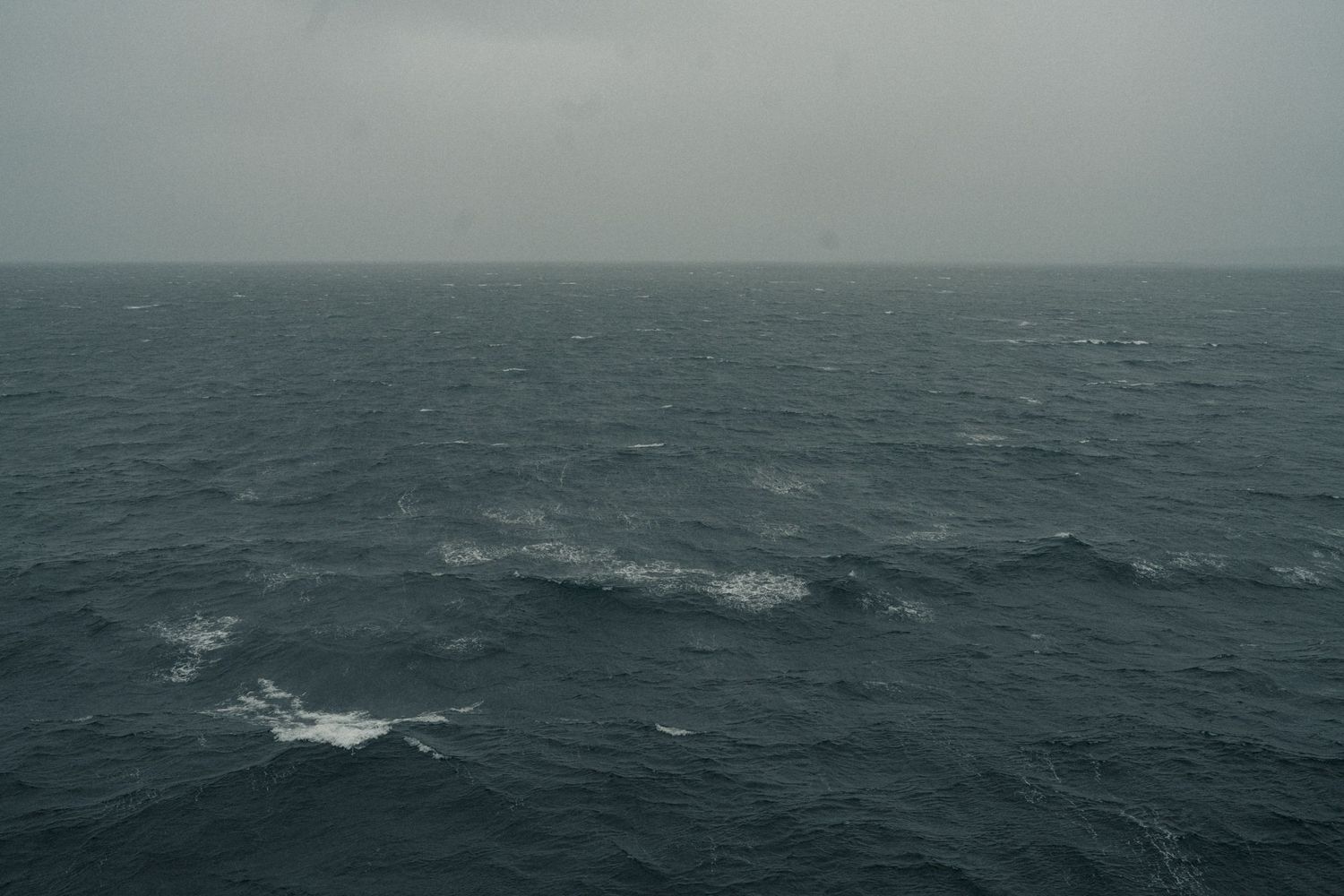 Dark stormy ocean seascape with overcast sky and choppy waves on a grey day.