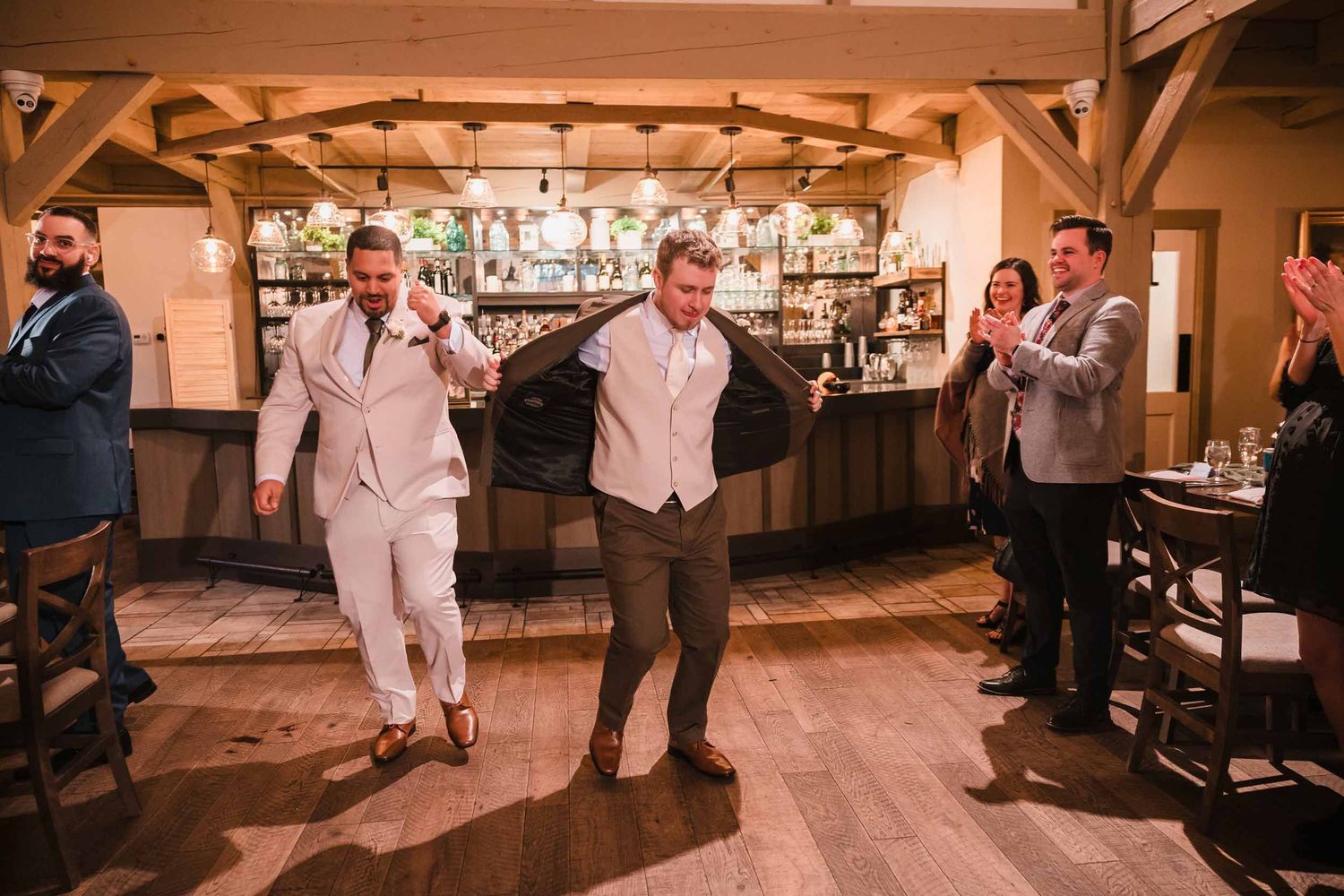 Grooms dancing into reception with guests cheering during grand entrance at Briar Barn Inn wedding