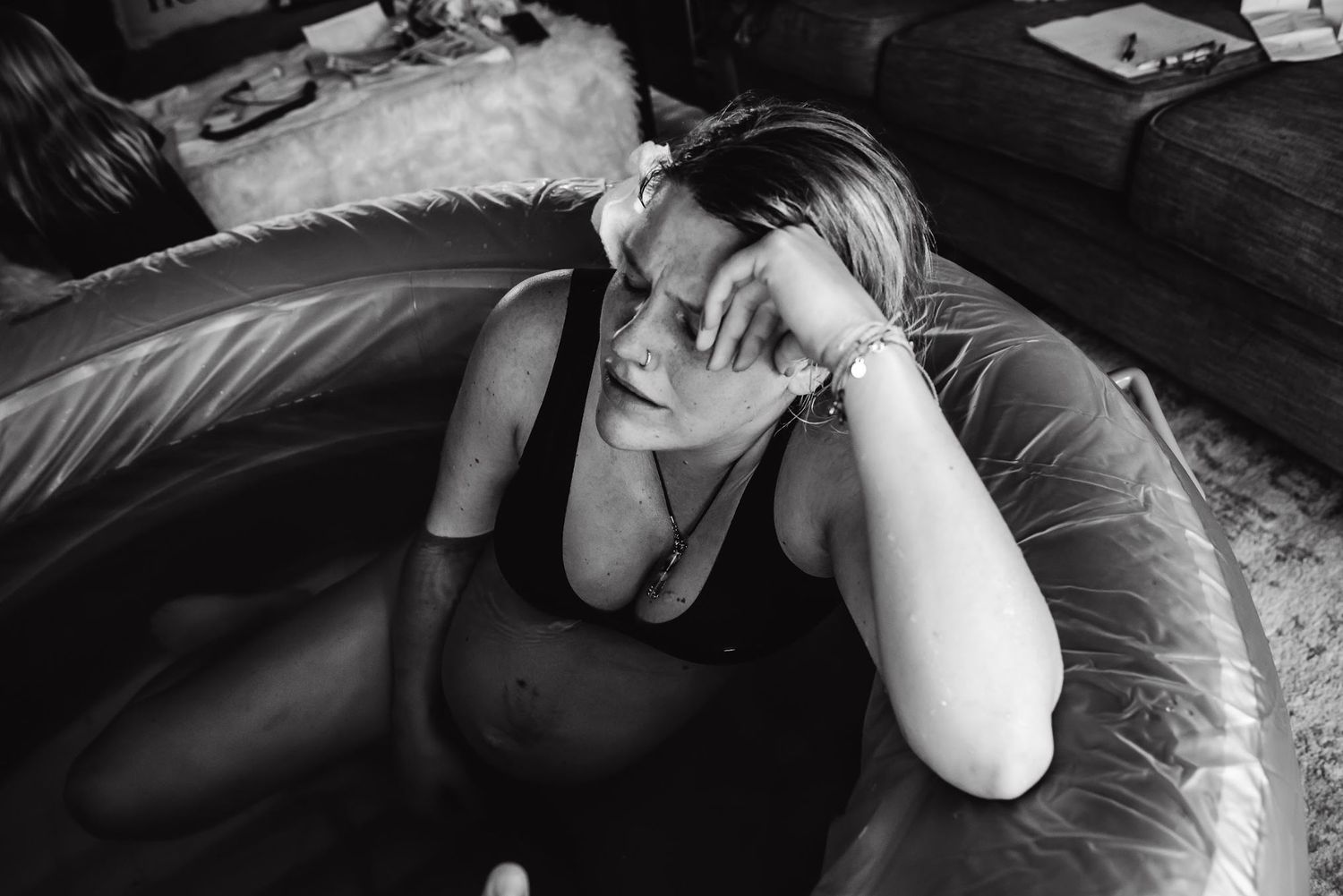 Person resting in birthing pool during labor at home.