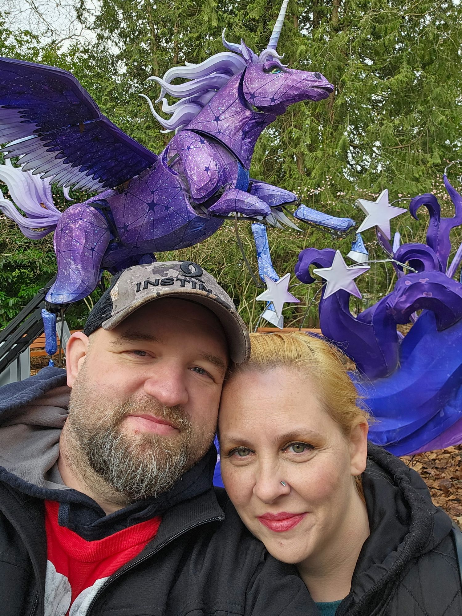 Couple selfie in front of colorful outdoor sculpture, fun candid moment