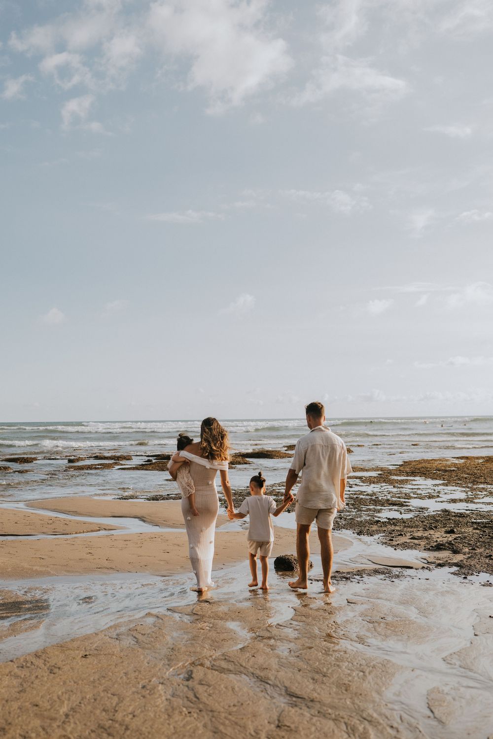 Beach family photography in Bali with an 
ocean backdrop