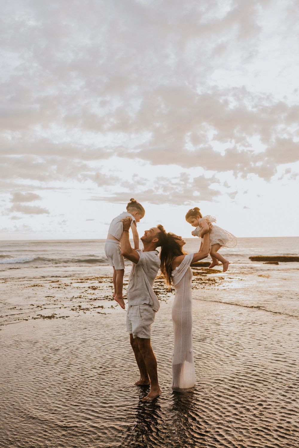 Beach family photography in Bali with an 
ocean backdrop
