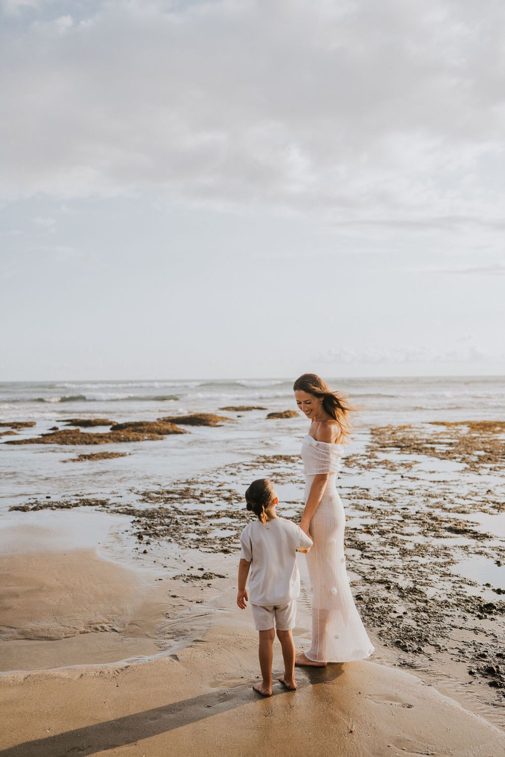 Beach family photography in Bali with an 
ocean backdrop