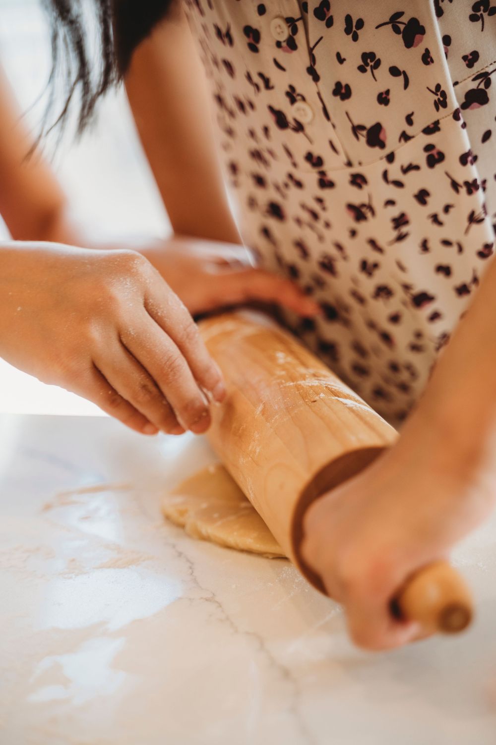 Mississauga photographer captures two little girls working together to sprinkle flour and roll out cookie dough
