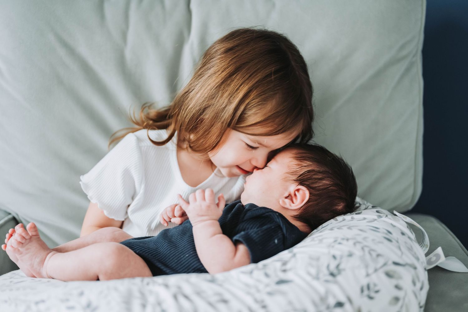Big sister snuggles newborn brother in newborn session with K. Manchuck Photography