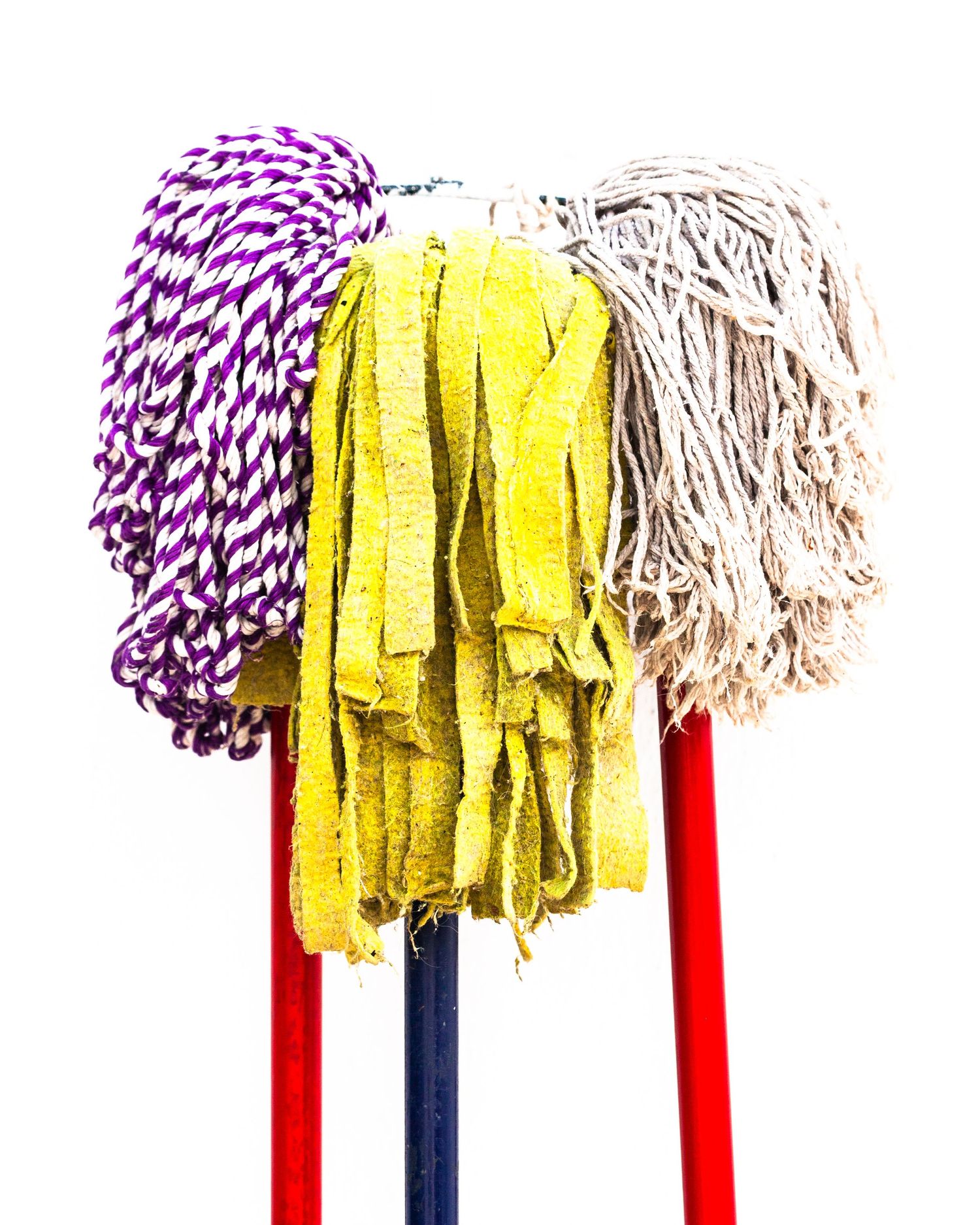 Three mops hanging outside a white house. Torrox, Andalucia, Spain.