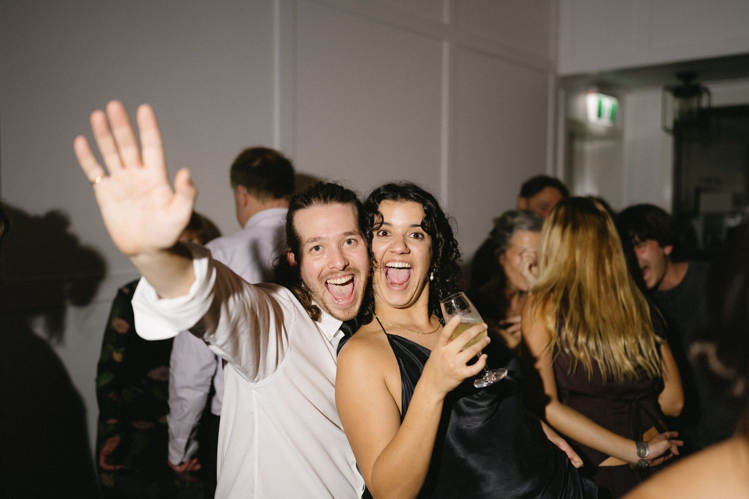 Guests celebrating joyfully on a lively wedding dance floor.