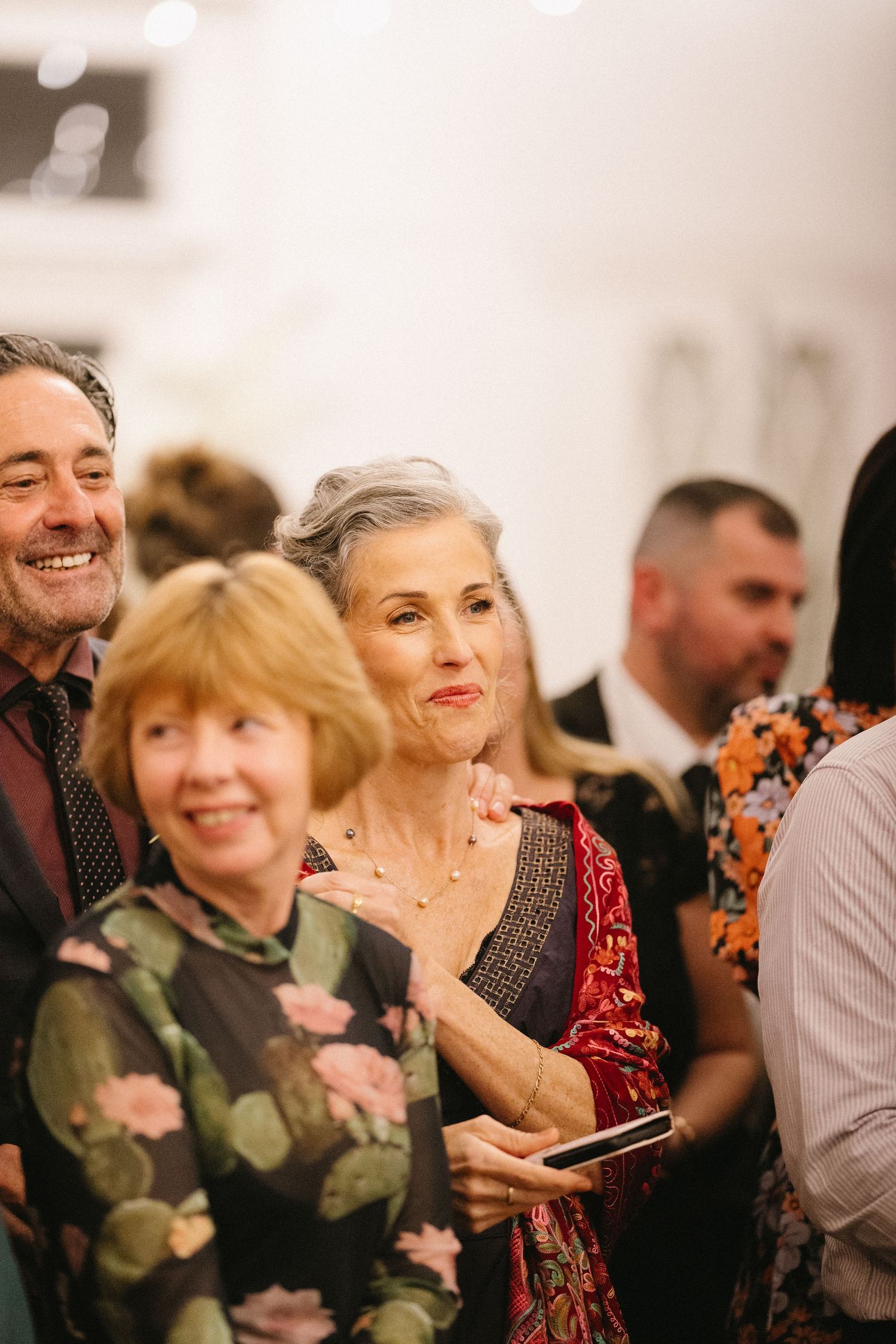 Guests enjoying themselves at an elegant formal gathering with warm ambient lighting.