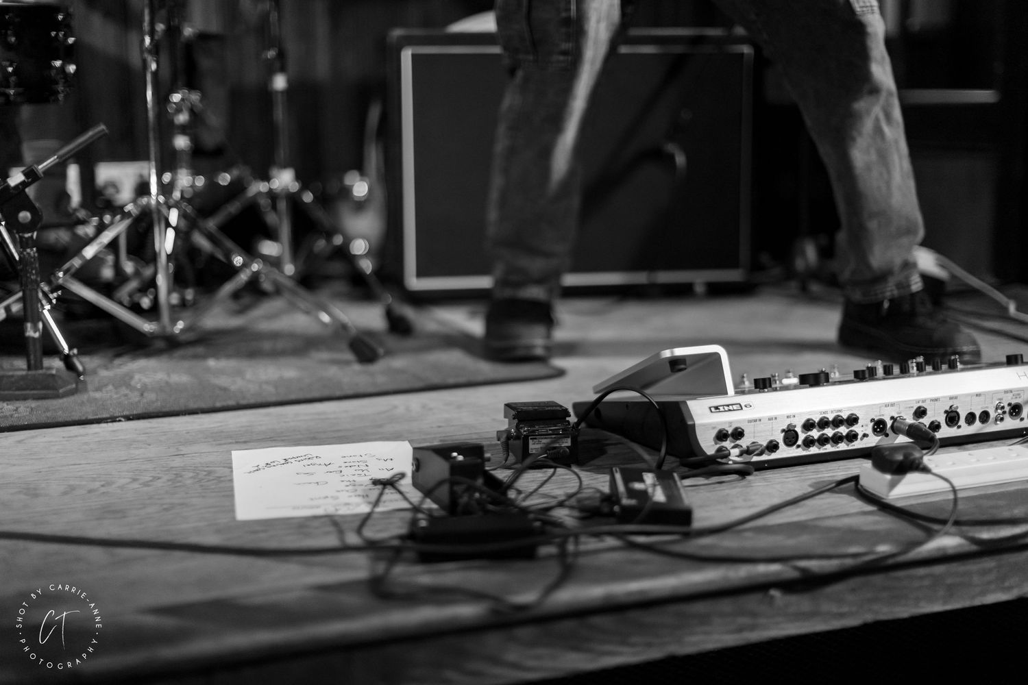 Stage equipment and instruments set up for live performance with dark lighting.