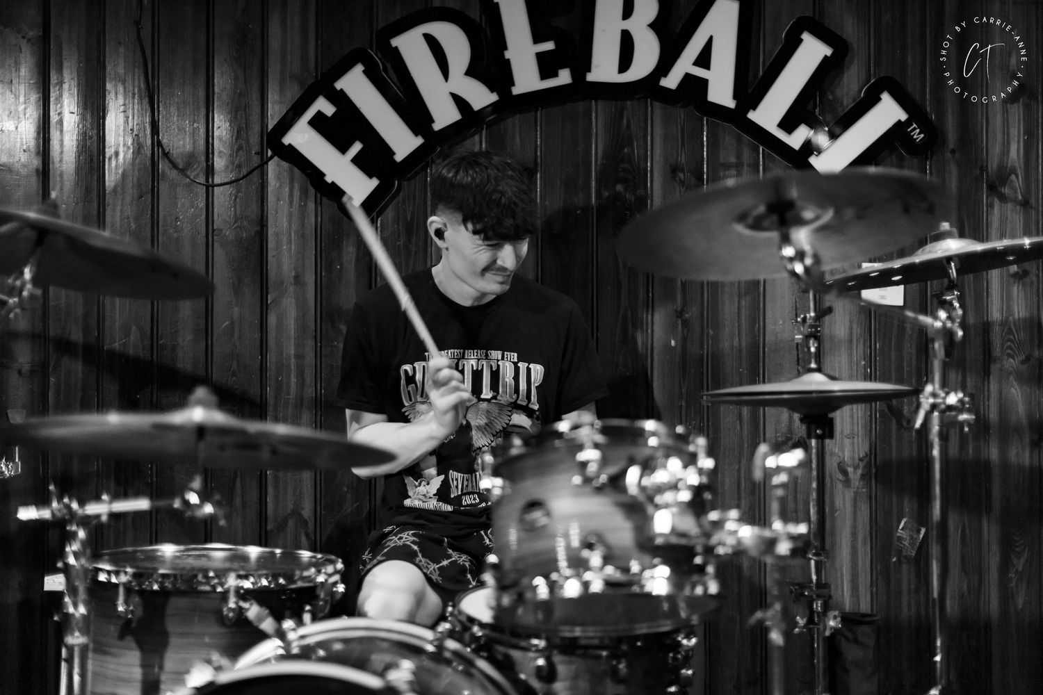 Dark venue interior with Fireball signage visible in background during performance.