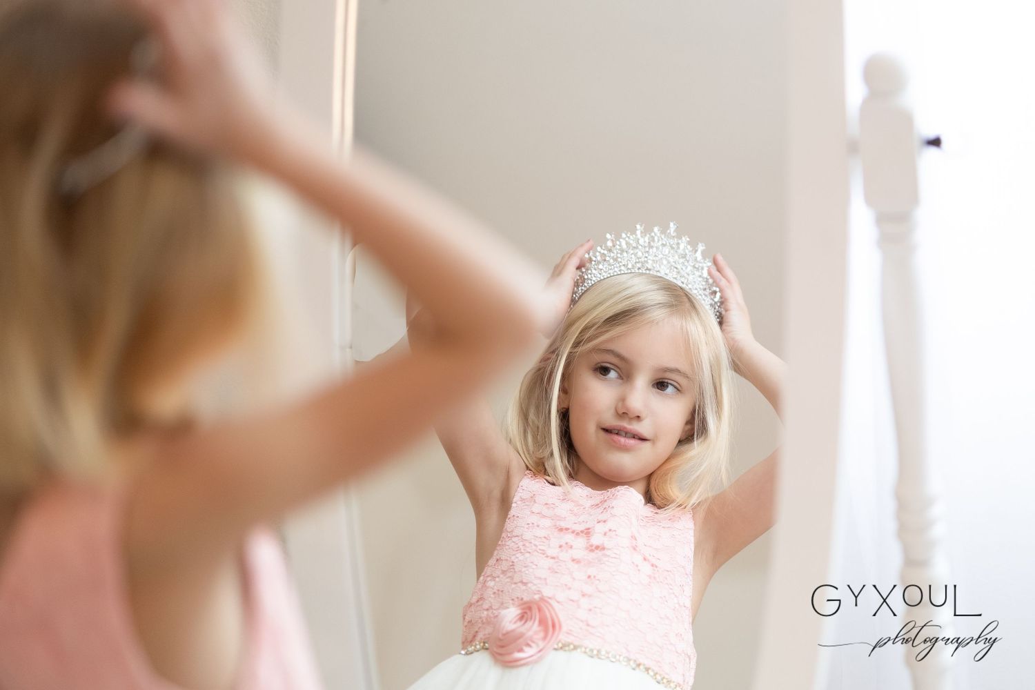 Playful mirror pose in a dreamy pink princess outfit.