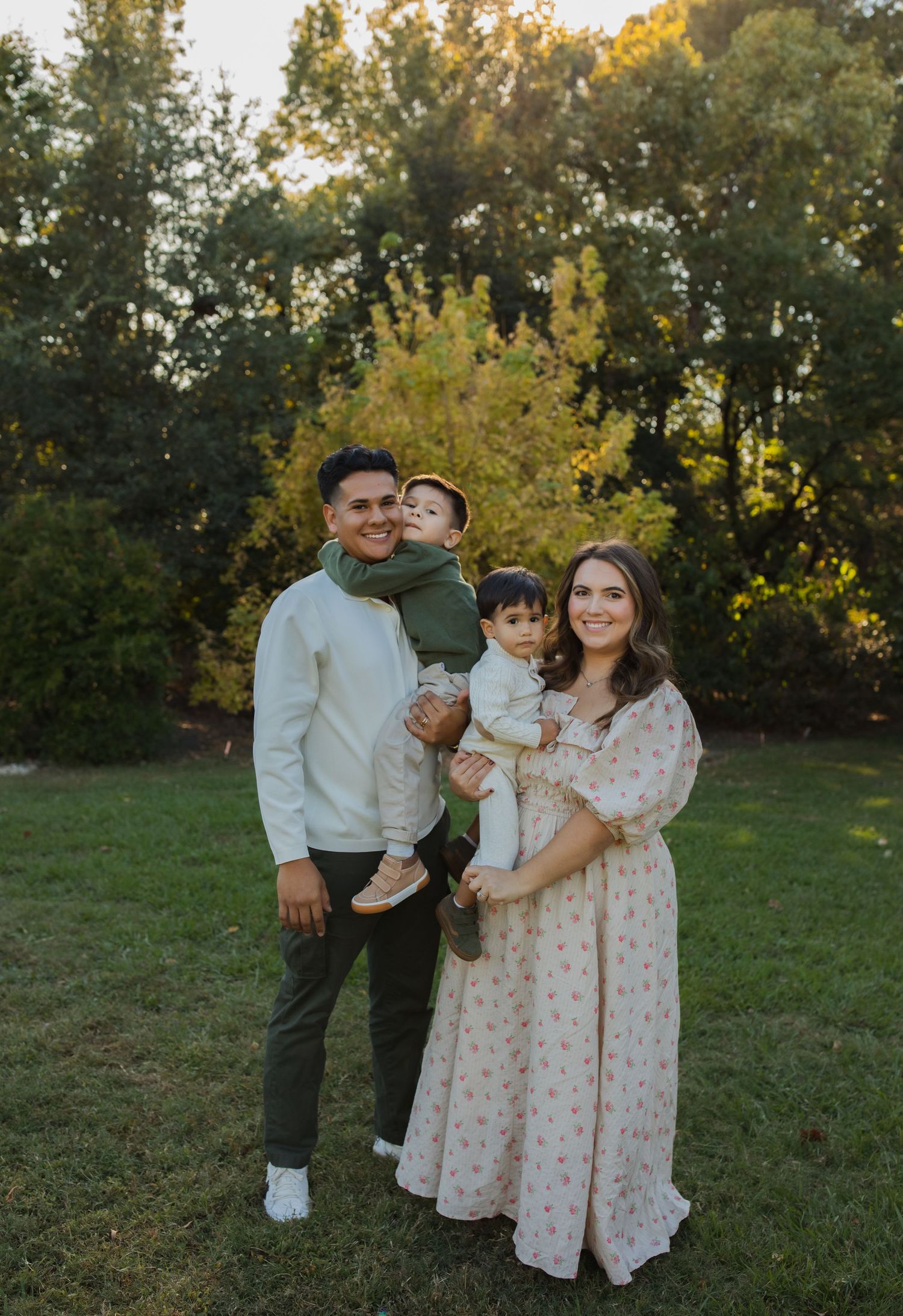 A family of four poses together in coordinated outfits during a sunset photo session.