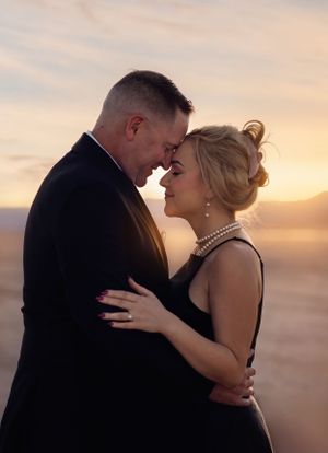 An intimate couple's portrait at sunset showing a tender moment in formal evening wear.