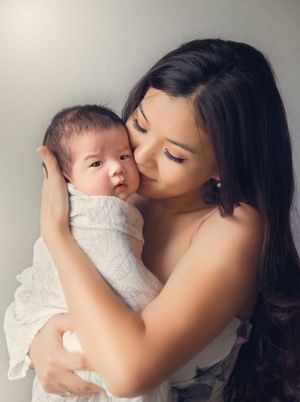 A tender moment between mother and baby during a studio portrait session.