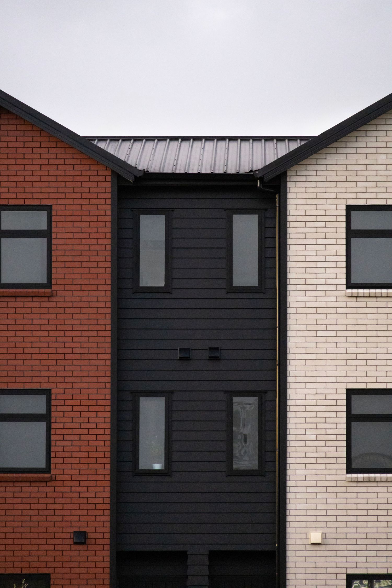 Row of houses with red, black, and white brick exteriors.