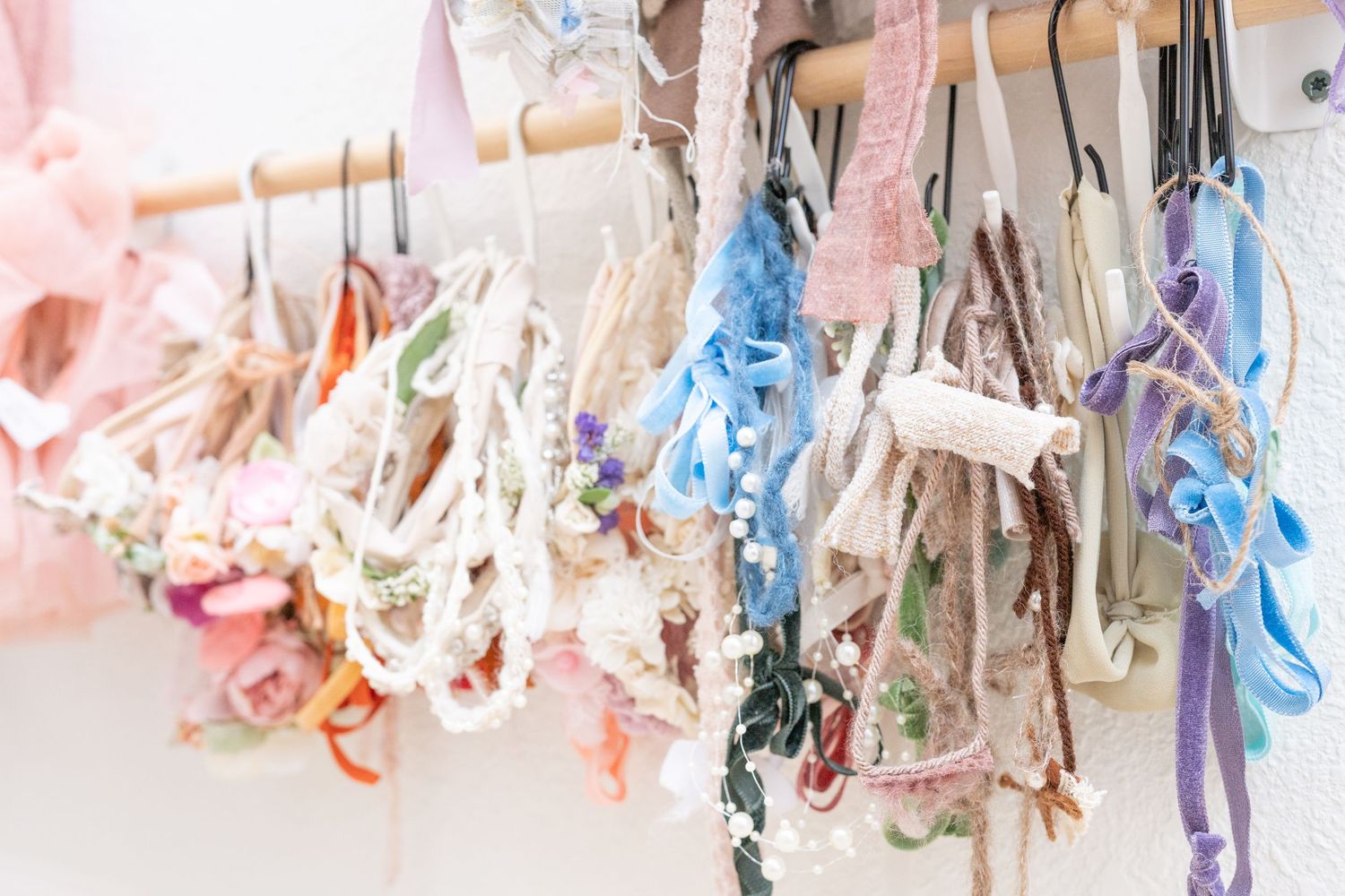 Delicate lingerie pieces in pastel colors hanging on display against a white background creating a soft romantic mood.