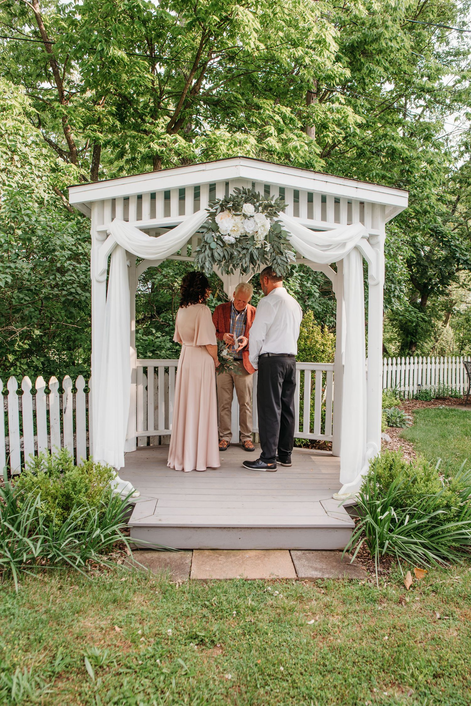 Wide view of a decorated wedding gazebo during the bride and groom's vows at the Appalachian Wedding Chapel.