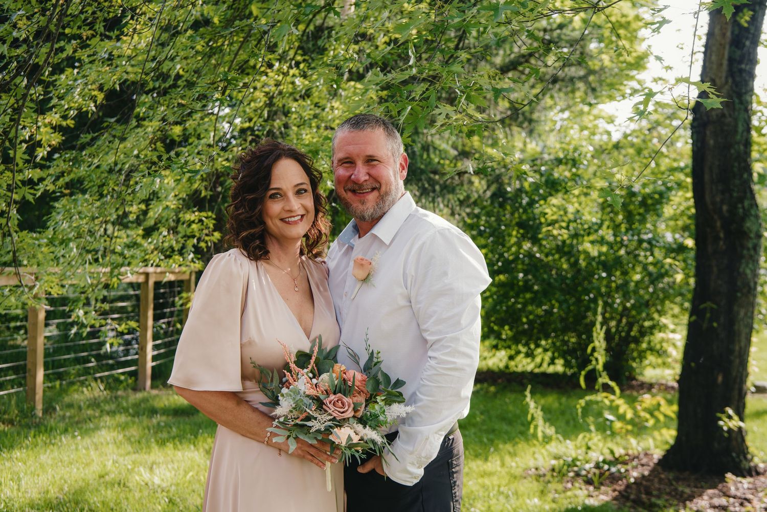 Couple sharing intimate moments in a sun-dappled garden setting at the Appalachian Wedding Chapel.