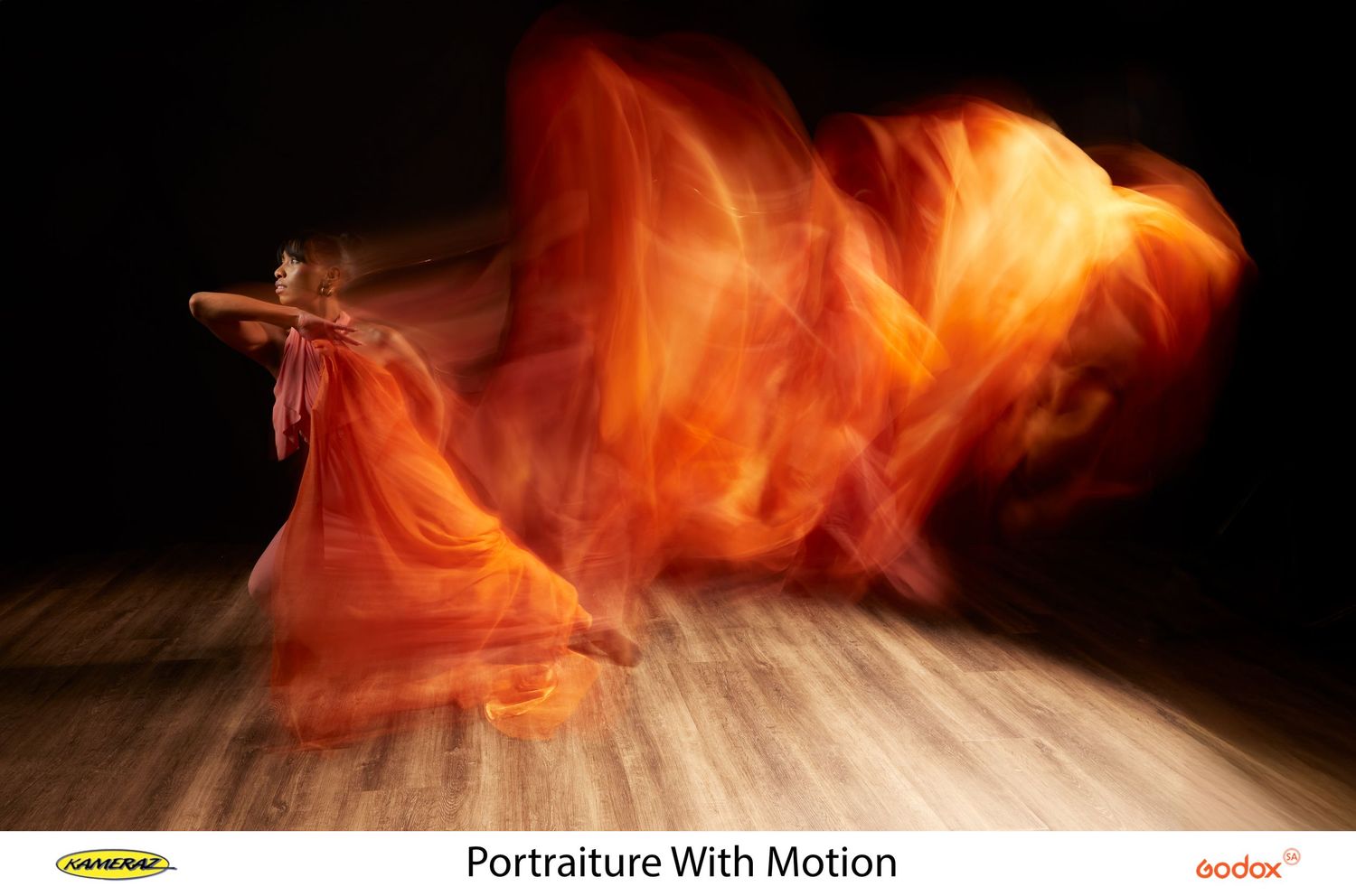 Long exposure photograph captures dancer in flowing orange dress creating dramatic motion blur effect on wooden stage floor.