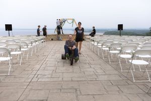 Panoramic view of white chairs arranged on a terrace overlooking a scenic landscape.